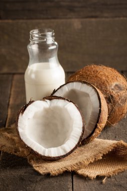 Olgun yarım Hindistan cevizi ahşap bir arka plan üzerinde kesmek..