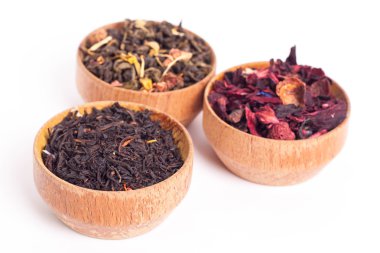 Ahşap Kaplamalar, beyaz zemin üzerine kuru çay. Kırmızı, yeşil ve siyah çay yaprakları. Makro fotoğraf.