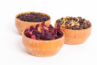 Ahşap Kaplamalar, beyaz zemin üzerine kuru çay. Kırmızı, yeşil ve siyah çay yaprakları. Makro fotoğraf.