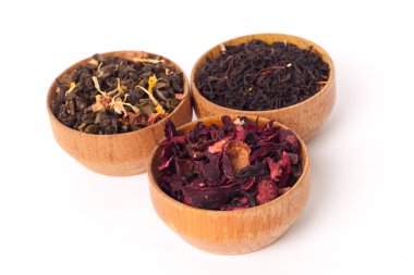 Ahşap Kaplamalar, beyaz zemin üzerine kuru çay. Kırmızı, yeşil ve siyah çay yaprakları. Makro fotoğraf.