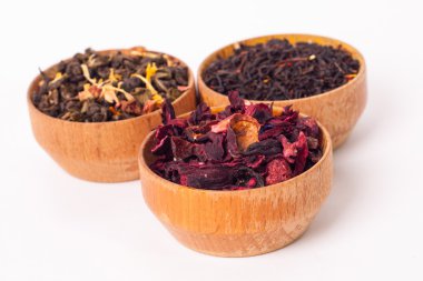 Ahşap Kaplamalar, beyaz zemin üzerine kuru çay. Kırmızı, yeşil ve siyah çay yaprakları. Makro fotoğraf.