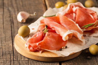 prosciutto ile karışık zeytin ve ahşap kesme tahtası üzerinde kırmızı biber ince dilim closeup