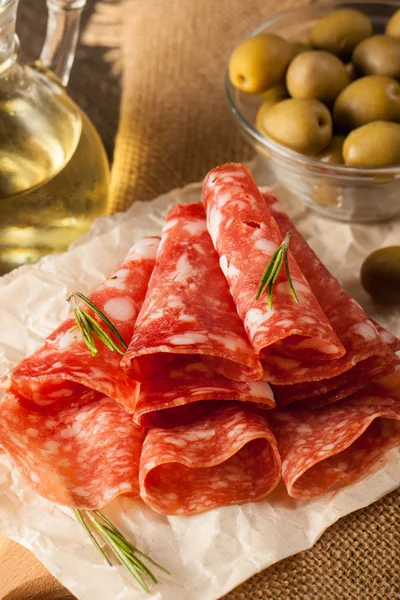 Salame italiano com azeitonas e especiarias em fundo de madeira — Fotografia de Stock