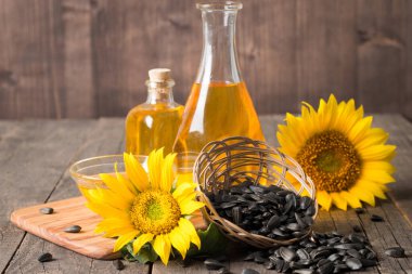 Geleneksel ahşap arka planda tohumları olan ayçiçeği yağı. 