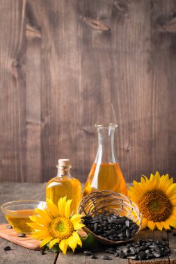 Geleneksel ahşap arka planda tohumları olan ayçiçeği yağı. 