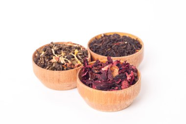 Ahşap Kaplamalar, beyaz zemin üzerine kuru çay. Kırmızı, yeşil ve siyah çay yaprakları. Makro fotoğraf.