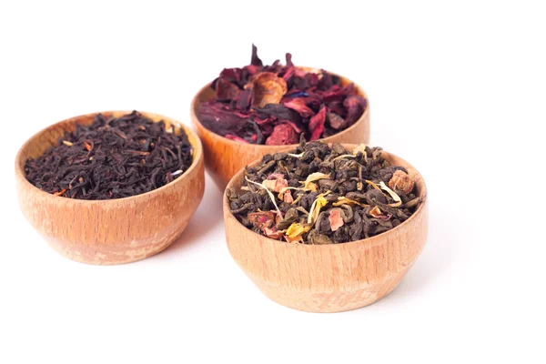 Dry tea in wooden plates, on white background. Leaves of red, green and black tea. Macro photo. — Stock Photo, Image