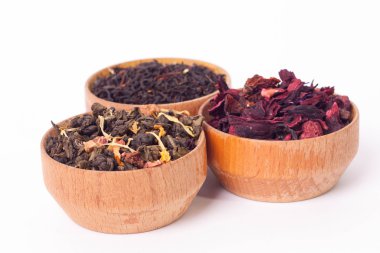 Ahşap Kaplamalar, beyaz zemin üzerine kuru çay. Kırmızı, yeşil ve siyah çay yaprakları. Makro fotoğraf.