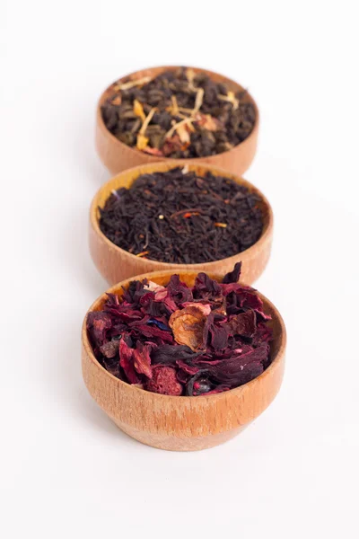 ชาแห้งในจานไม้ บนพื้นหลังสีขาว ใบชาแดง เขียว และดํา แมคโครภาพ . — ภาพถ่ายสต็อก