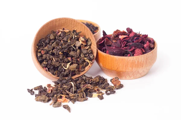 Сухой чай в деревянных тарелках, на белом фоне. Листья красного, зеленого и черного чая. Макро фото . — стоковое фото
