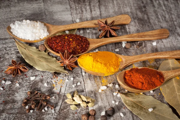 Des épices. Épice en cuillère en bois. Des herbes. Curry, safran, curcuma, cannelle et autres sur un fond rustique en bois. Du poivre. Grande collection d'épices et d'herbes différentes. Sel, paprika . — Photo