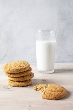 Tahta masada bir bardak sütle kurabiyeler.