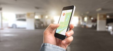 Elle tutulan akıllı telefon aygıtı ekrana ve navigatör GPS haritasına dokunuyor