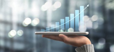 İşadamı, elinde tabletle iş yerinde grafik büyümesi ve grafik artışı planlıyor