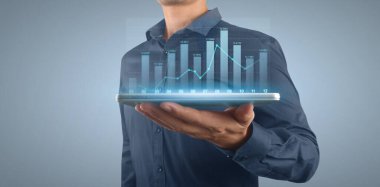 İşadamı, elinde tabletle iş yerinde grafik büyümesi ve grafik artışı planlıyor