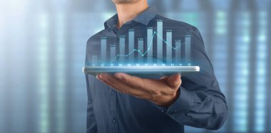 İşadamı, elinde tabletle iş yerinde grafik büyümesi ve grafik artışı planlıyor