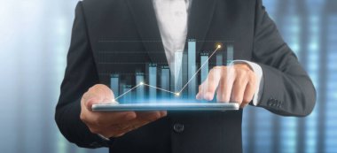 İşadamı, elinde tabletle iş yerinde grafik büyümesi ve grafik artışı planlıyor