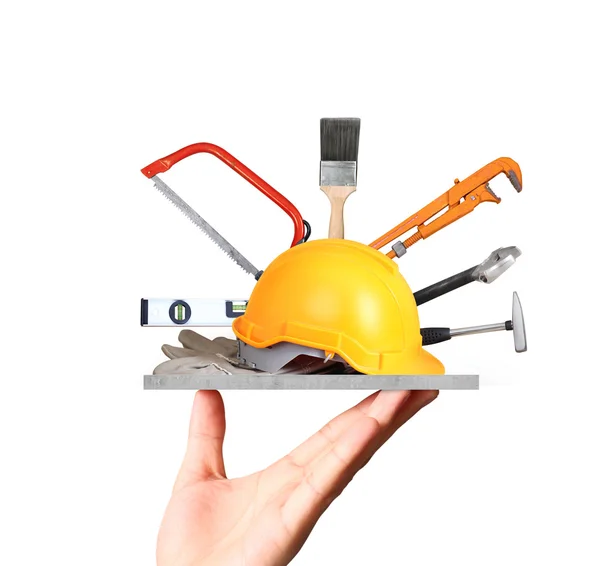 Yellow helmet plastic safety and tools in hand — Stock Photo, Image