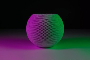 White HomePod mini with pink and green light clipart