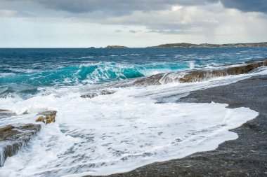 Bella fırtınasından dalgalı denizler Korsika 'nın Balagne bölgesindeki Punta Caldanu' daki kayalık Akdeniz kıyılarına vuruyor.