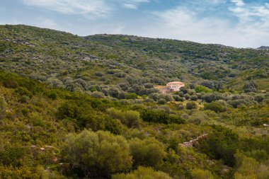 A deserted farm building surrounded by lush green maquis at Ifana in Corsica
