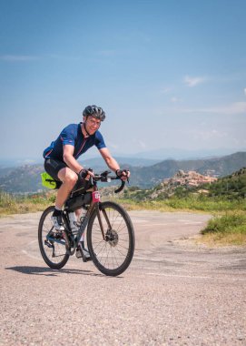 Speloncato, Korsika, Fransa - 9 Haziran 2021: Damian Grandjanny Speloncato köyünde 780 km gittikten sonra 2021 Bisikletçi Korsika yarışında yarışıyor. Bisikletçi Korsika, adayı desteksiz bir şekilde çevreleyen yıllık 1000 kilometrelik bir dayanıklılık bisikleti etkinliğidir..