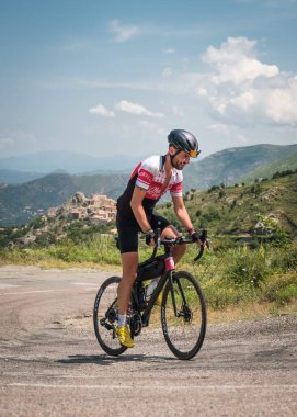 Speloncato, Korsika, Fransa - 9 Haziran 2021: Adrien Foix Speloncato köyünde 780 km gittikten sonra 2021 Bisikletçi Korsika yarışında yarışıyor. Bisikletçi Korsika, adayı desteksiz bir şekilde çevreleyen yıllık 1000 kilometrelik bir dayanıklılık bisikleti etkinliğidir..