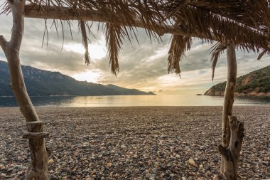 Corsica'deki / daki Bussaglia plajda plaj çubuğundan göster