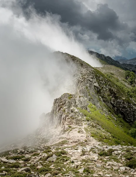 Wolken voldoen aan de bovenkant van een bergrug op Gr20 in Corsica — Stockfoto