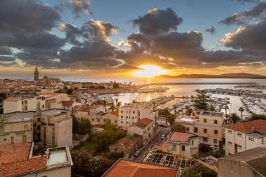 Sunset over city of Alghero on west coast of Sardinia clipart