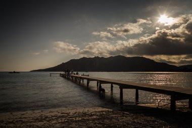 İnsanlar Corsica'deki / daki Santa Giulia plajda iskele üzerinde