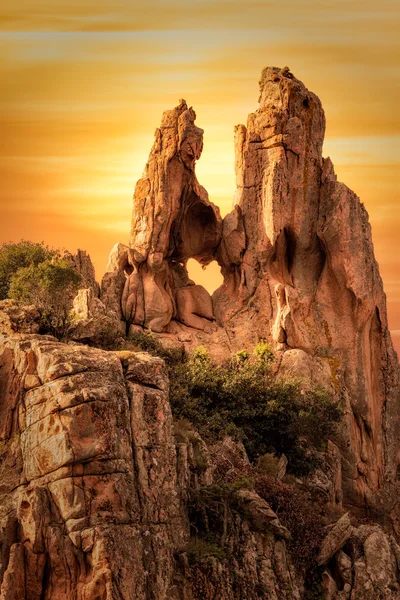 Дыра в форме сердца в скале в Calanches на Корсике на закате — стоковое фото