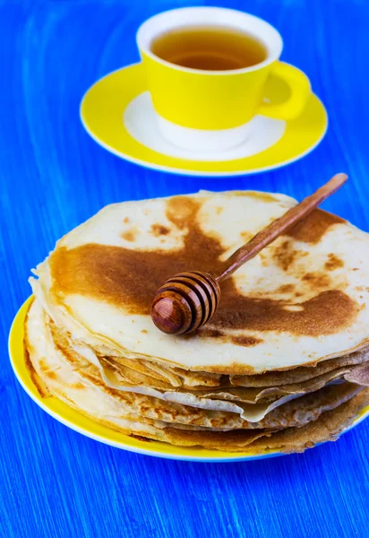 Pancakes with honey on a yellow plate — Stock Photo, Image