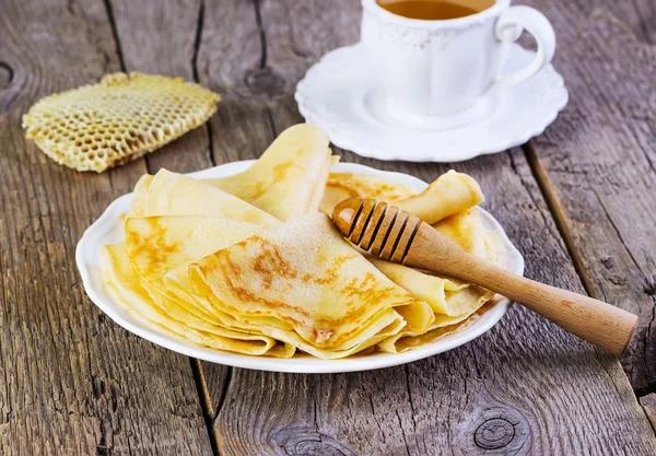 Tortitas con miel en un plato blanco —  Fotos de Stock