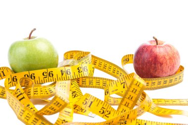 Kırmızı ve yeşil elma ve beyaz arka plan üzerinde bir ölçüm bandı.