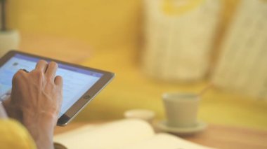 Kafede kahve içme ve telefon ve tablet kullanarak genç adam