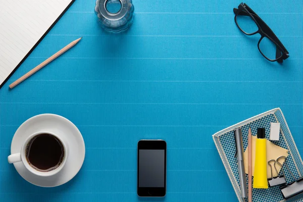 Office werkplek, kantoor apparatuur en koffiepauze op blauwe crêpe — Stockfoto