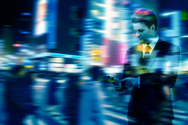 Double exposure of businessman uses the smart phone on the city street, and motion blur background — Stock Photo, Image