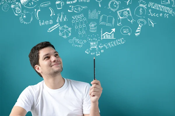 Jeune homme et crayon avec des icônes croquantes — Photo