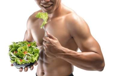Genç mutlu kaslı adam beyaz arka plan üzerinde izole bir salata yemek