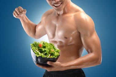 Şeklinde bir kas adam ve taze salata kasesi, karın