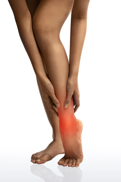 Acute pain in a woman ankle. Woman holding hand to spot of ankle-aches.with clipping path — Stock Photo, Image