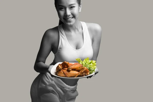 Νεαρή γυναίκα με το τέλειο σώμα, κρατώντας και δείχνοντας ψητό κοτόπουλο — Φωτογραφία Αρχείου