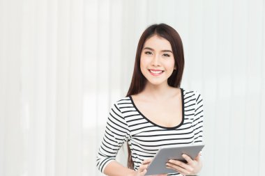 beautiful young woman on the workplace using a digital tablet clipart