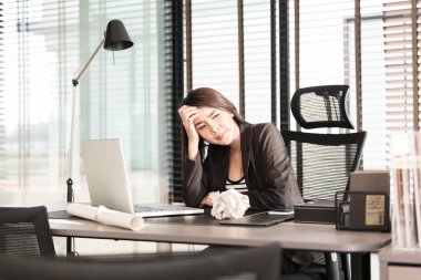 yorgun ve uykulu genç iş kadını ile bir dizüstü bilgisayar masası