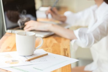 kahve fincanı ve işkadını belgeleri ve dizüstü bilgisayar ile çalışma
