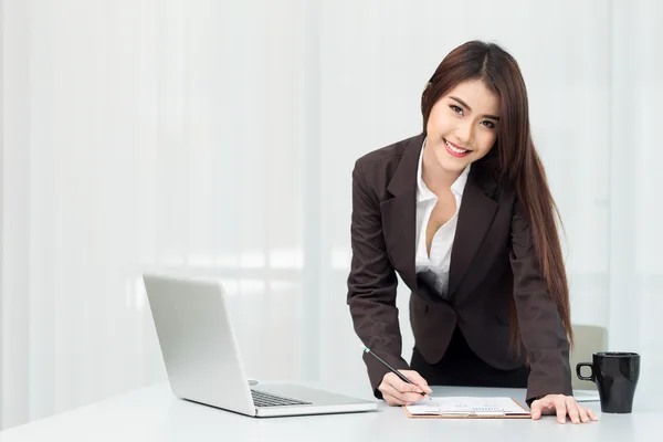 Portrait d'une jeune femme d'affaires utilisant un ordinateur portable au bureau — Photo