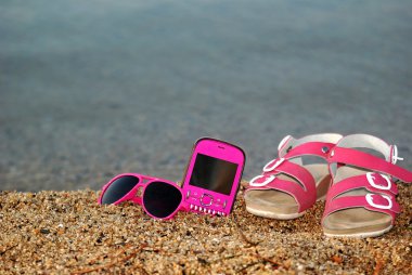 Gözlük, sandalet ve cep telefonu