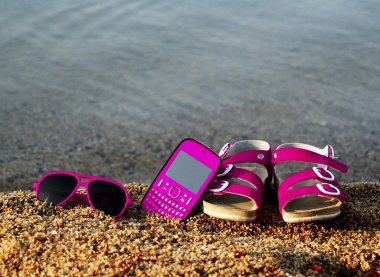 Gözlük, sandalet ve cep telefonu