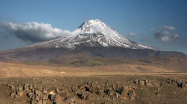 Karlı volkanik yüksek irtifa dağ konisi. Tüm stratovolkanolar ve kalkan volkanları yüzeyde bir koni oluşturma eğilimindedir. Konik bağlama, belirgin konik şekli olan bir arazi şeklidir. Bazıları daha kule şeklinde ve dairesel. 4K